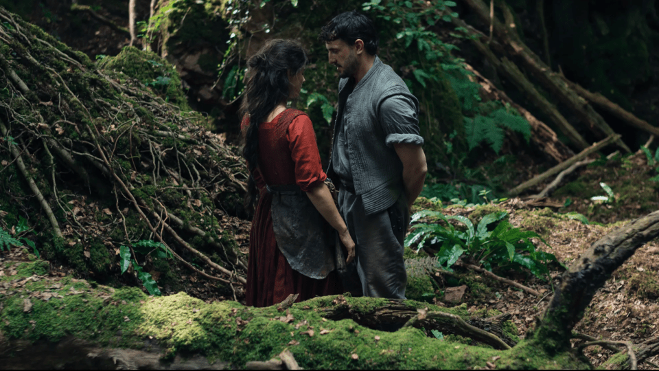 Agnes Hathaway and William Shakespeare stand near each other in a forest.